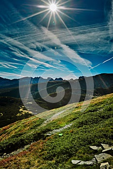 Landscape view in Seven Rila lakes with green fields and mountains, sun shining background