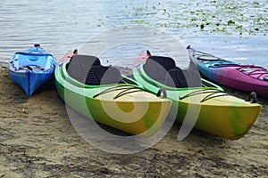 Landscape view of several colorful kayaks at the river shore. Boats on the city sandy beach, Obolon, Kyiv, Ukraine