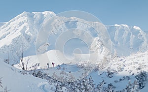 Landscape view of ski touring couple hiking up a mountain in the Low Tatras in Slovakia.