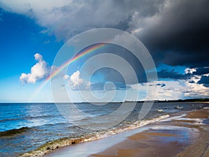 Landscape view on sky with rainbow at sea.