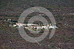 Landscape view of small European mountain village with old rustic Mediterranean houses next to modern family house surrounded with