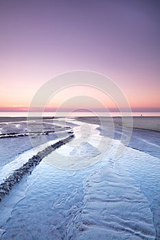 Landscape view of a sunset in a pink sky on the beach and West Coast of Jutland, Denmark. A beautiful sunrise on the