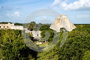 Landscape view of Uxmal archeological site with pyramids and ruins