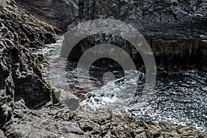 Landscape of a volcanic coast with black rocks, Atlantic ocean. Selective focus. Los Gigantes, Tenerife
