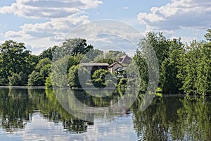landscape from the water of the lake against the background of green trees of private houses