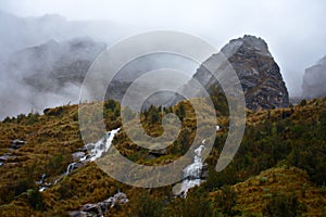 Landscape of a waterfall on a mountain covered in clouds in Huascaran National Park