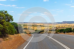 Landscape of Western Australia besides the road with hills and farm