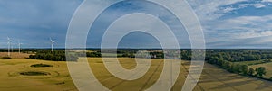 Landscape with a wheat field, wind mills and agricultural silo. Panorama of agricultural factory, wheat field in the countryside.