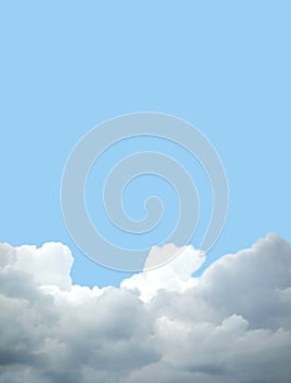 Landscape with white and gray rain clouds on the bottom of photo and clear blue sky above on bright sunny day vertical view