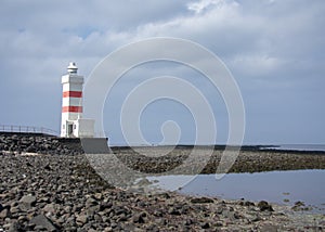 Landscape of white orange lighthouse near Keflavik Iceland