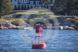 Landscape wide shot selective focus of Floating red navigational buoy on blue sea