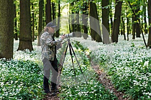 Landscape or wildlife photographer is setting camera on tripod