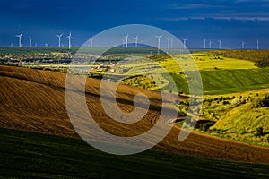 Landscape with wind turbines. Green field and freshly ploughed field. Location: Romania