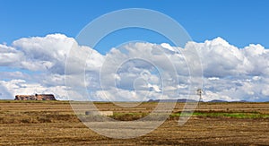 Landscape of a windmill and fields with white cloud and blue sky