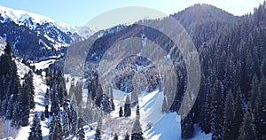 Landscape winter forest. Mountain area. A group of people goes and rides in the mountains on a snow-covered trail.