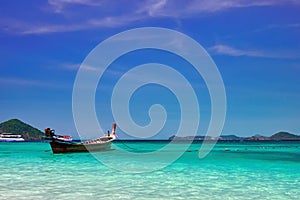 Landscape with wooden fishing longtail boat at noon tropical sea with turquoise water. Seascape Concept of aboriginal life in Asia