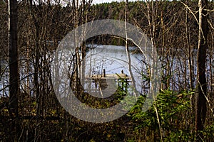 Landscape, wooden pier on the lake, autumn view of the forest by the lake, reflection of trees on the water