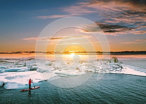 Landscaped, Beautiful glacier lagoon in sunset with a guy paddle boarding