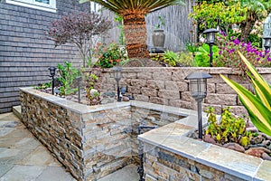 Landscaped garden with stone brick half walls and plants in San Diego California