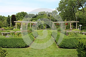 Landscaped gardens with two arbors in front of a wooded area at Rotary Botanical Gardens in Wisconsin