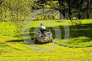 Landscaper cutting grass on riding lawn mower