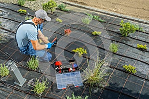 Landscaper Installing Another Hose Bracket in a Drip Irrigation Pipeline