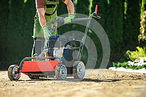 Landscaper Pushing Lawn Aerator photo