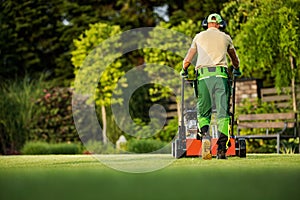 Landscaper Pushing Scarifier Machine Taking Care of the Lawn