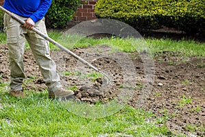 Landscapers gardeners mowing lawn with the rake is on the ground spring