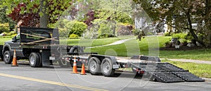 Landscaping truck with empty flatbed trailer