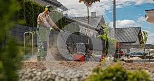 Landscaping Worker Preparing Soil Using Aerator photo