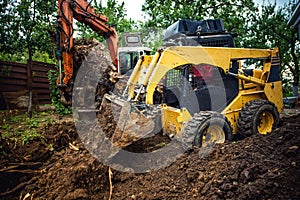 Landscaping works with bulldozer and excavator at home construction site