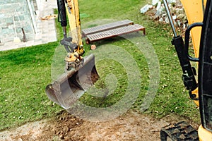 Landscaping works with bulldozer and excavator at home construction site. Terrain works