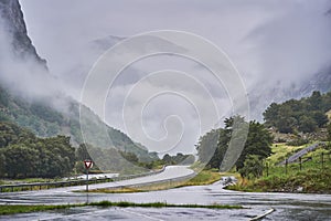 Landscpe picture of the asphalt crossroad in the norwegian mountains covered by clouds photo