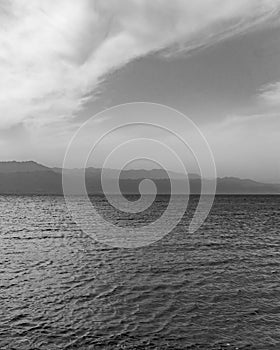 Landskape of foggy mountains across red sea in black and white.