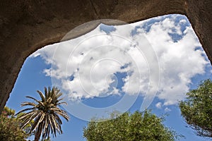 A landskape with trees and cloudy sky from inside an east architecture bui