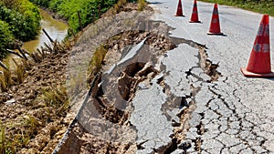 Landslide caused by rains occurs broken road asphalt. Broken asphalt road collapsed and fallen.  Road collapses. Cracked asphalt r