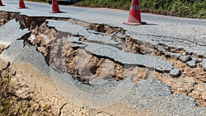 Landslide caused by rains occurs broken road asphalt. Broken asphalt road collapsed and fallen.  Road collapses. Cracked asphalt r
