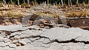 Landslide caused by rains occurs broken road asphalt. Broken asphalt road collapsed and fallen.  Road collapses. Cracked asphalt r