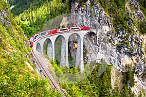 Landwasser Viaduct in summer, Filisur, Switzerland. It is landmark of Swiss Alps. Nice Alpine landscape. Red train of Bernina photo