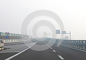 lane of motorway without cars but with a lot of dangerous fog which reduces visibility