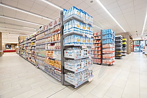 Lanes of shelves with aisle of goods products inside a supermarket