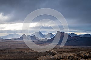 Langjokull Glacier epic mountain formations under dark clouds with small gaps of sun