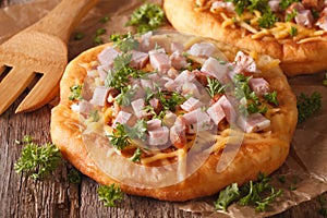 Langos deep fried with cheese and ham close-up. Horizontal