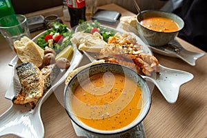 Langoustine soup and Langoustine grilled with salle on a white fish-shaped platter.