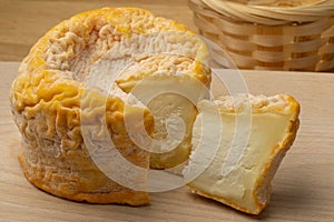 Langres cheese refined with champagne and a piece on a cutting board