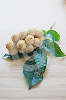 Langsat with green leave on wood table