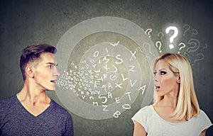 Language barrier concept. Handsome man talking to an attractive woman with question mark photo