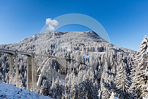 train viaduct Langwies in Switzerland in sunshine, winter, snow, blue sky