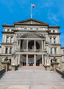 Lansing MI - May 6, 2023: Main entrance to the Michigan Capitol building with ornate marble, steps and lamppost